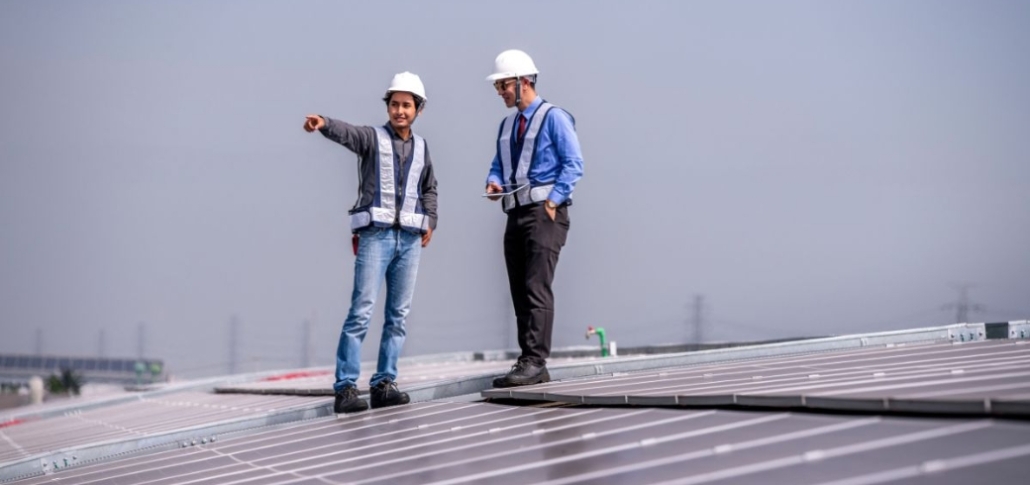 Two men on a rooftop, highlighting options for commercial roof replacement and selecting the best contractor.