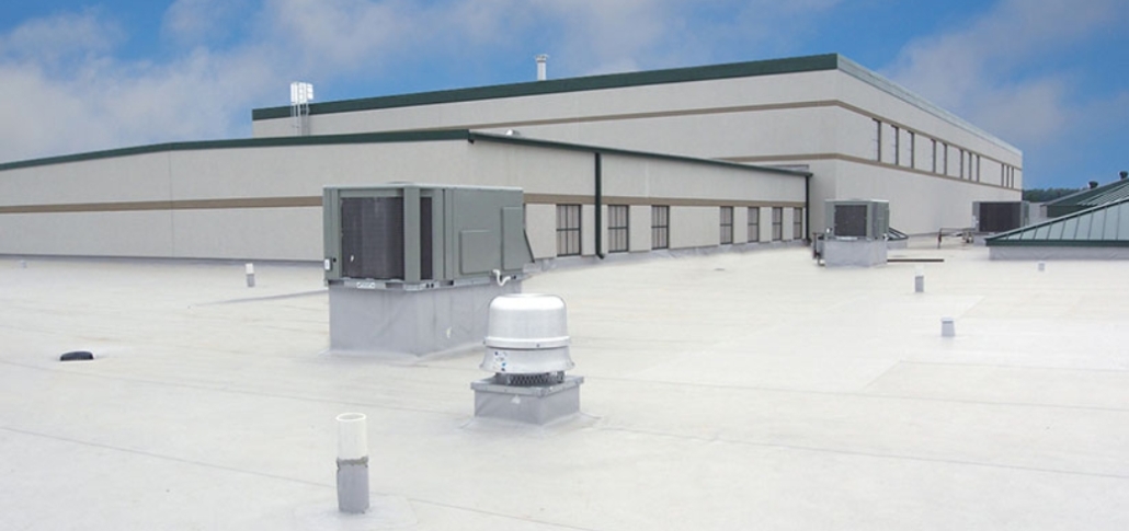 A large industrial structure equipped with air conditioning units and drainage, focusing on commercial roof replacement and drainage systems.