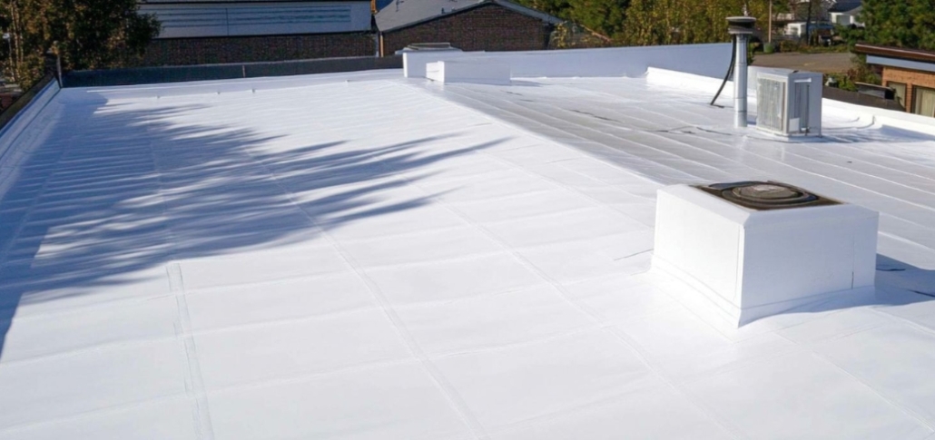 A commercial building's roof with a white PVC covering, highlighting the roof replacement process.