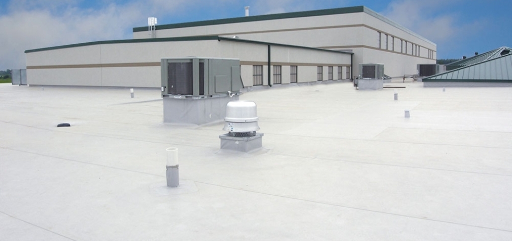 Large white building with a roof and AC units, serving as a visual reference for post-replacement maintenance tips.
