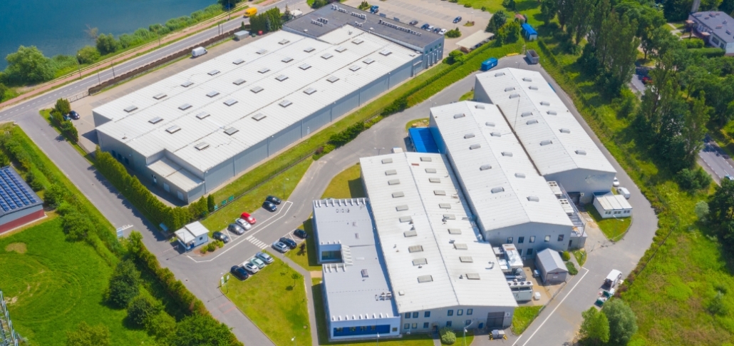 Aerial view of a large industrial building, highlighting its roof, relevant to commercial roofing material discussions.