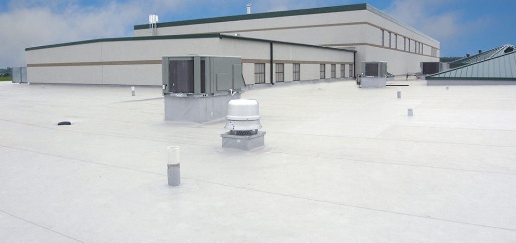A prominent white building with a roof and air conditioning units, illustrating the topic of PVC roofing systems.
