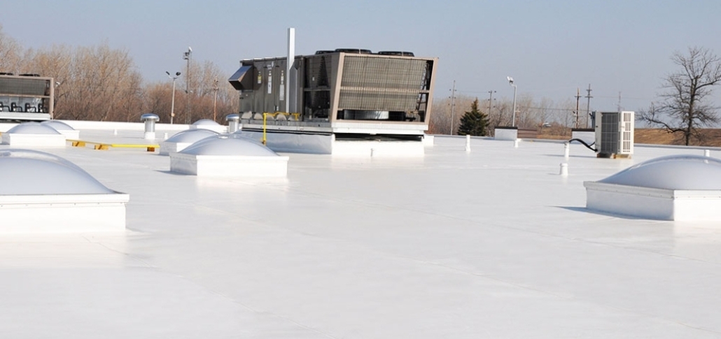A flat roof featuring white TPO roofing and multiple air conditioning units installed on top.