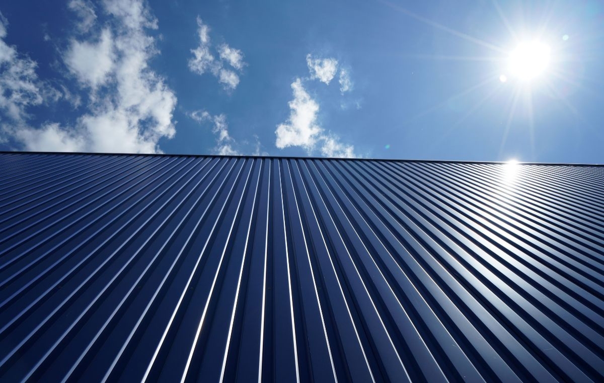 A blue metal roof illuminated by sunlight, showcasing Commercial Metal Roofing in Rhode Island.