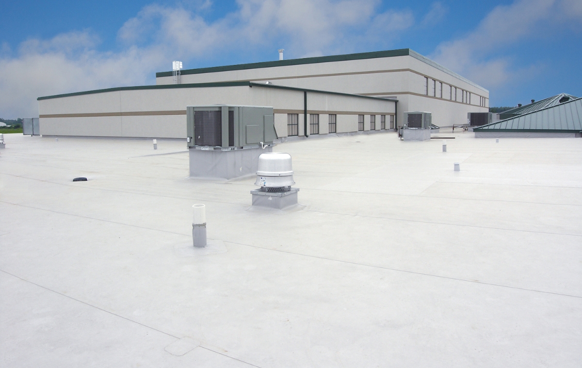 Large white commercial building with a roof and air conditioning, showcasing a focus on roof repair services.