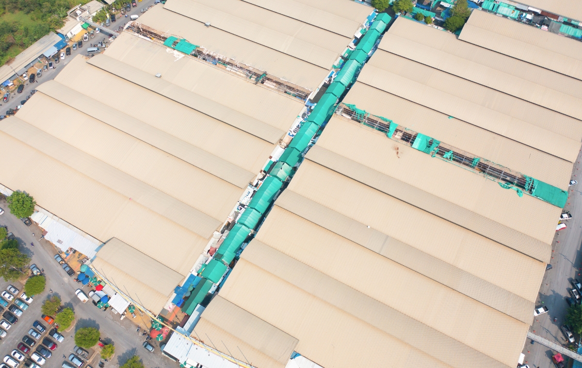 Aerial perspective of a busy warehouse with multiple trucks, representing commercial roofing services in Hartford, CT.