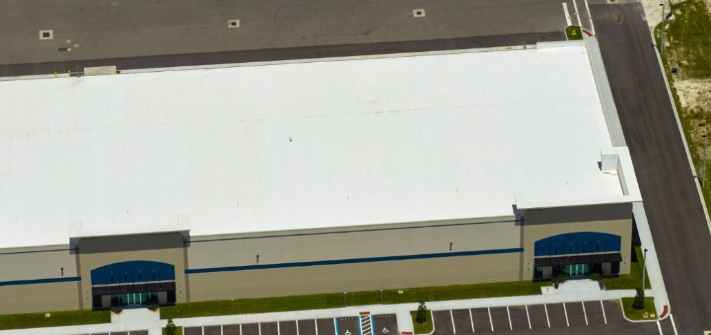 Aerial view of a large warehouse building, emphasizing the roof's suitability for commercial solar panel assessment.