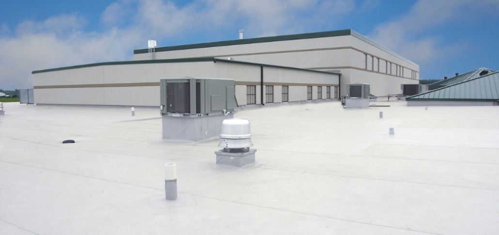 A prominent white building with a roof equipped with air conditioning units, representing TPO roofing systems for industrial use.