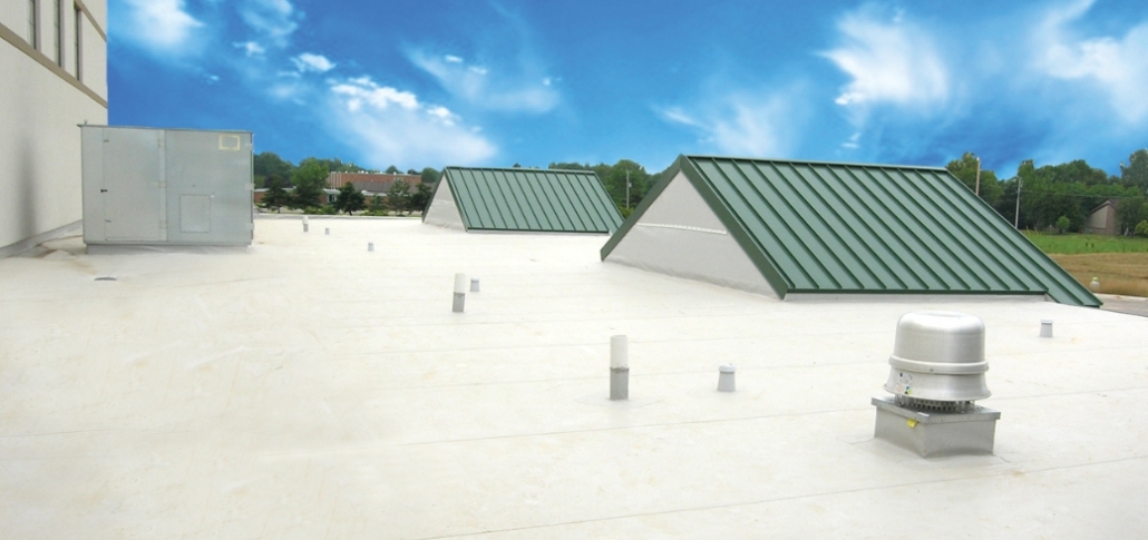 Warehouse with a green metal roof and white flat roof, featuring Duro-Last for quick and customized roofing installations.