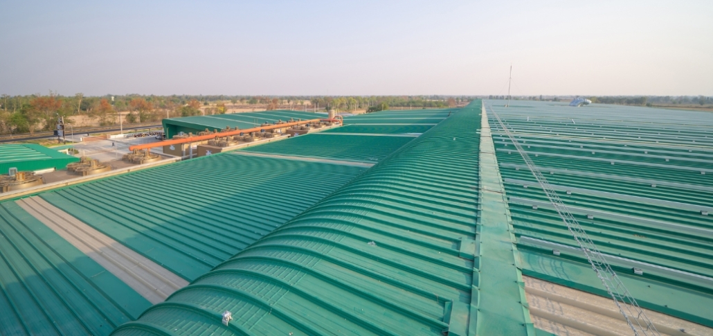 A factory building featuring a green roof, promoting sustainability and longevity in metal roofing solutions.