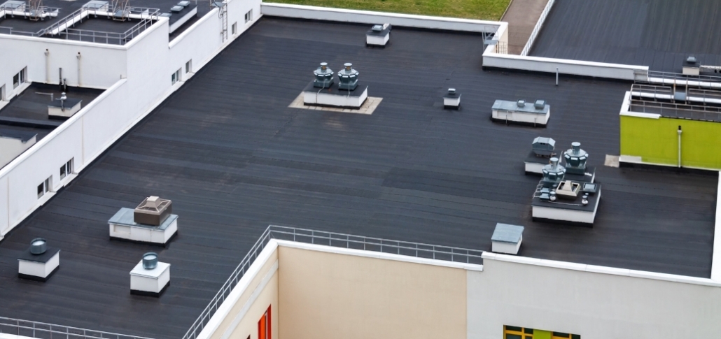 Aerial perspective of a building showcasing its roof, designed for manufacturing with modified bitumen and BUR.